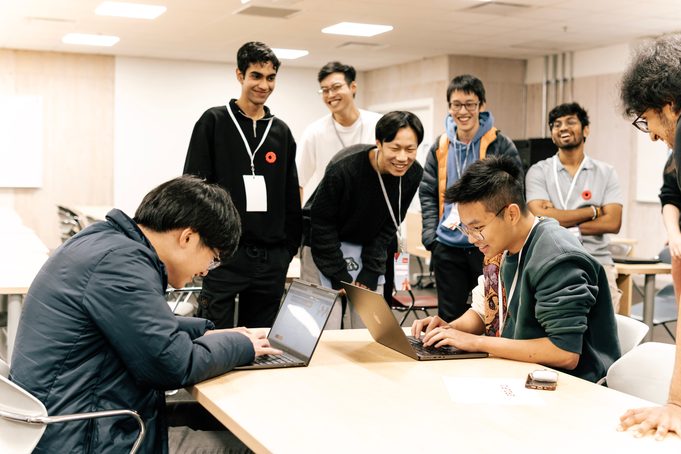 A team gathered around a laptop at a table